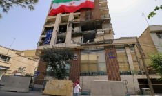 Un immeuble détruit par une frappe israélienne recouvert du drapeau iranien, à Téhéran le 25 juin 2025 ( AFP / ATTA KENARE )