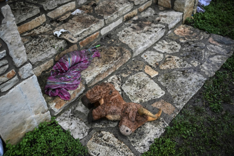 Un jouet en peluche est abandonné sur le sol devant une cabane au Camp Mystic, le site où au moins 20 filles ont disparu après des inondations soudaines à Hunt, au Texas, le 5 juillet 2025 ( AFP / RONALDO SCHEMIDT )