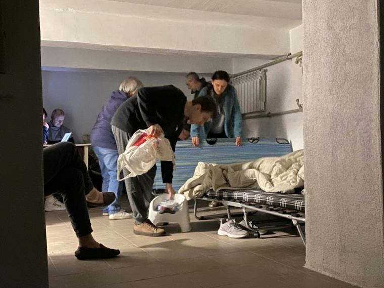 Des habitants s'installent pour dormir dans le sous-sol de leur immeuble résidentiel pendant une attaque nocturne de drones et de missiles sur Kiev, le 23 juin 2025 en Ukraine ( AFP / Ania TSOUKANOVA )