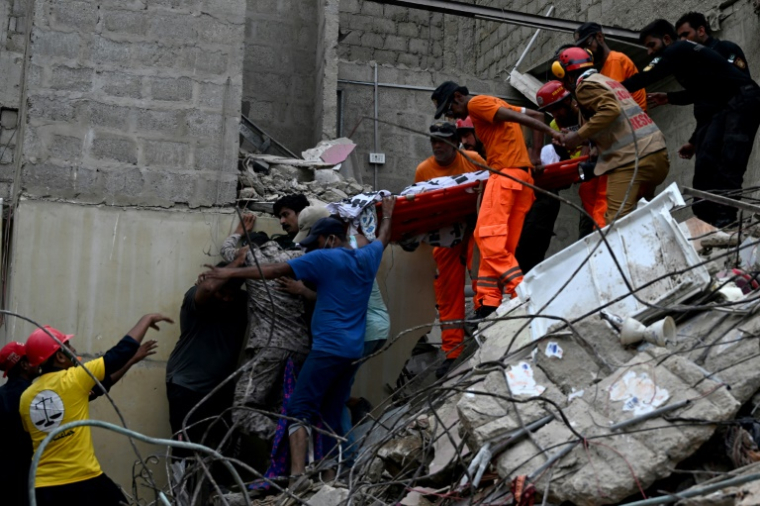 Les secours évacuent le corps d'une victime sur une civière après l'effondrement d'un immeuble d'habitation à Karachi, le 4 juillet 2025 ( AFP / Rizwan TABASSUM )
