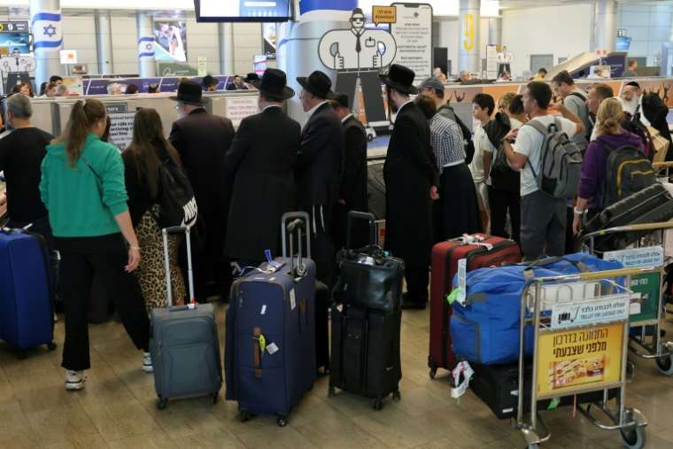 Des passagers attendent leurs bagages à l'aéroport Ben Gourion de Tel-Aviv, le 25 juin 2025 ( AFP / Jack GUEZ )