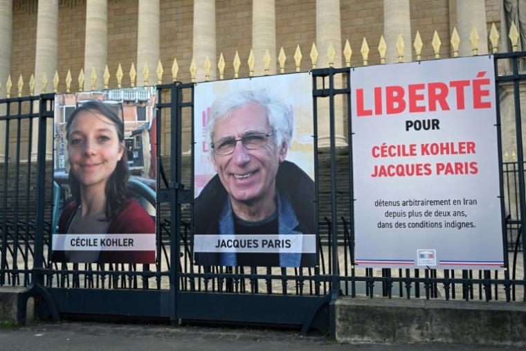 Les photos de Cécile Kohler et Jacques Paris sur les grilles de l'Assemblée nationale à Paris le 25 mars 2025 ( AFP / BERTRAND GUAY )