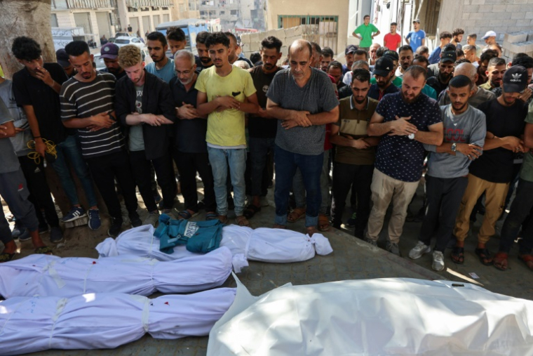 Des Palestiniens prient près des corps de leurs proches tués lors d'une frappe israélienne contre le café Al-Baqa, sur le front de mer de Gaza-ville, à l’hôpital Al-Chifa de la ville, le 30 juin 2025 ( AFP / Omar AL-QATTAA )