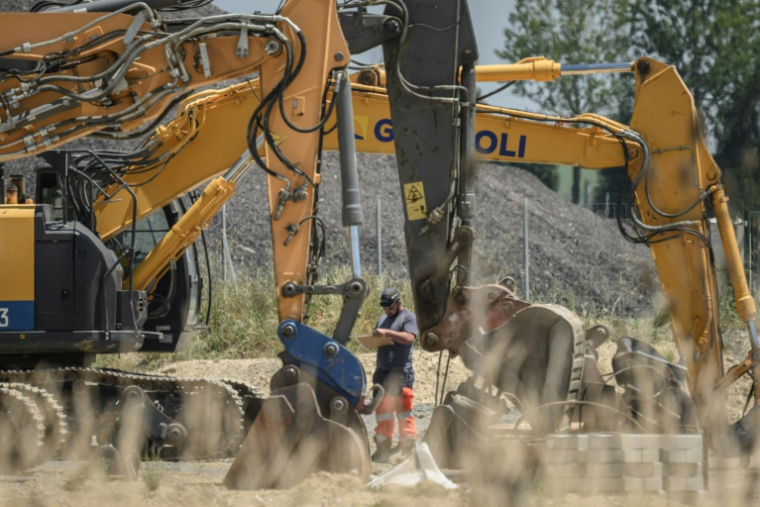 Un ouvrier se tient à côté de pelles mécaniques sur le chantier de l'autoroute A69 près de Verfeil, dans le Tarn-et-Garonne, le 17 juin 2025 ( AFP / Ed JONES )