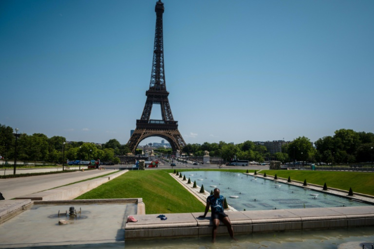 Un homme se rafraichit pendant une vague de chaleur à Paris, au Trocadéro, face à la tour Eiffel, le 1er juillet 2025 ( AFP / Dimitar DILKOFF )