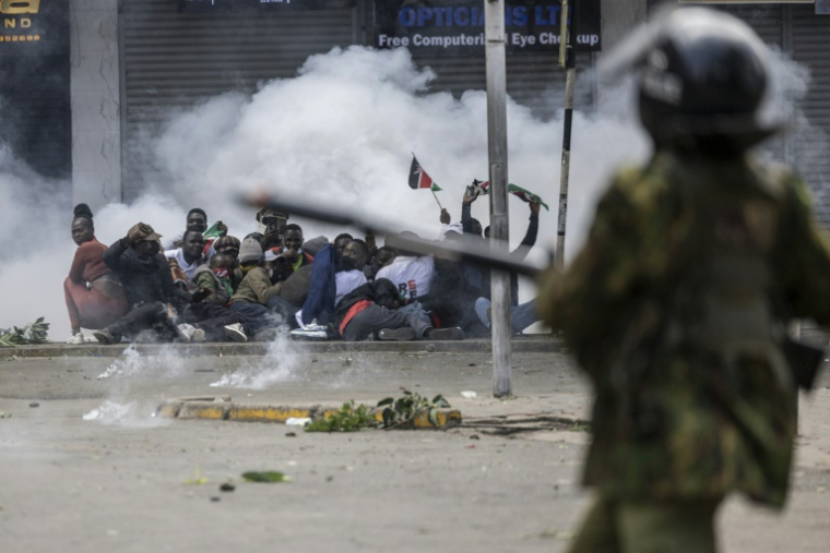 Des manifestants se mettent à couvert alors que la police tire des gaz lacrymogènes, le 25 juin 2025 à Nairobi, au Kenya ( AFP / SIMON MAINA )