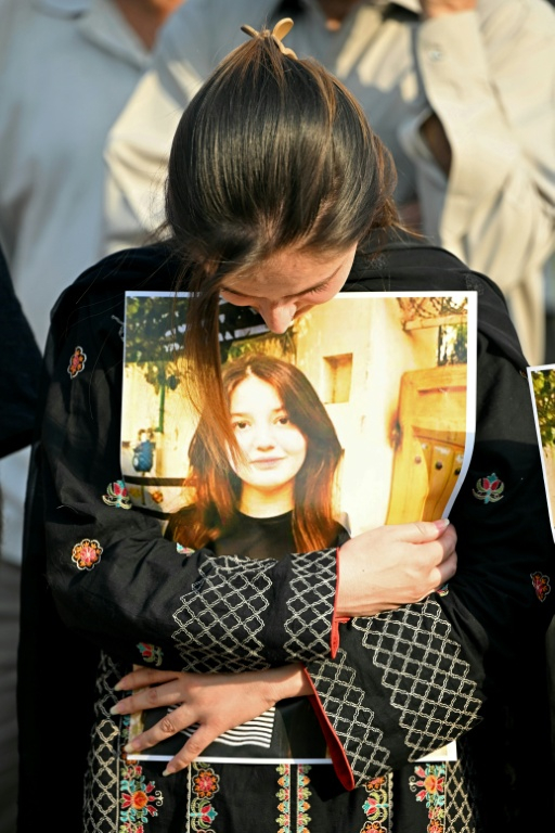 Une femme, présente à un rassemblement en hommage à Sana Yousaf le 5 juin 2025 à Islamabad au Pakistan, serre entre ses bras un portrait imprimé de la jeune influenceuse de 17 ans assassinée ( AFP / Farooq NAEEM )