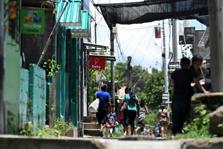 Des passants dans le quartier du 10 de Octubre à San Marcos, au Salvador, le 14 juin 2025 ( AFP / Marvin RECINOS )