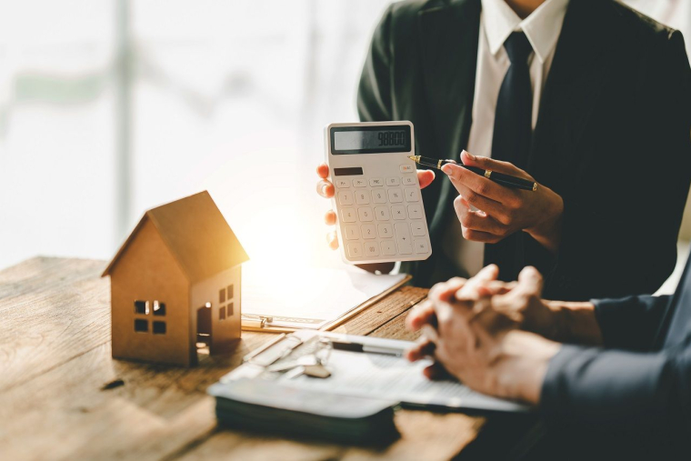 une maison et une calculatrice (Crédits: Adobe Stock)