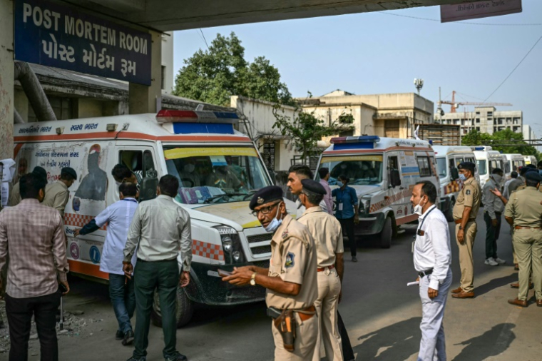 Des ambulances garées près de la salle d'autopsie d'un hôpital avant de transférer les corps des victimes vers une morgue, au lendemain du crash du vol 171 d'Air India dans un quartier résidentiel, près de l'aéroport d'Ahmedabad, le 13 juin 205 en Inde ( AFP / Punit PARANJPE )
