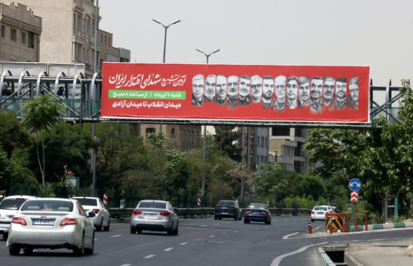 Une banderole avec les portraits de responsables militaires iraniens tués pendant la récente guerre avec Israël appelle à participer à une procession funéraire prévue le 28 juin, le 26 juin 2025 à Téhéran  ( AFP / ATTA KENARE )