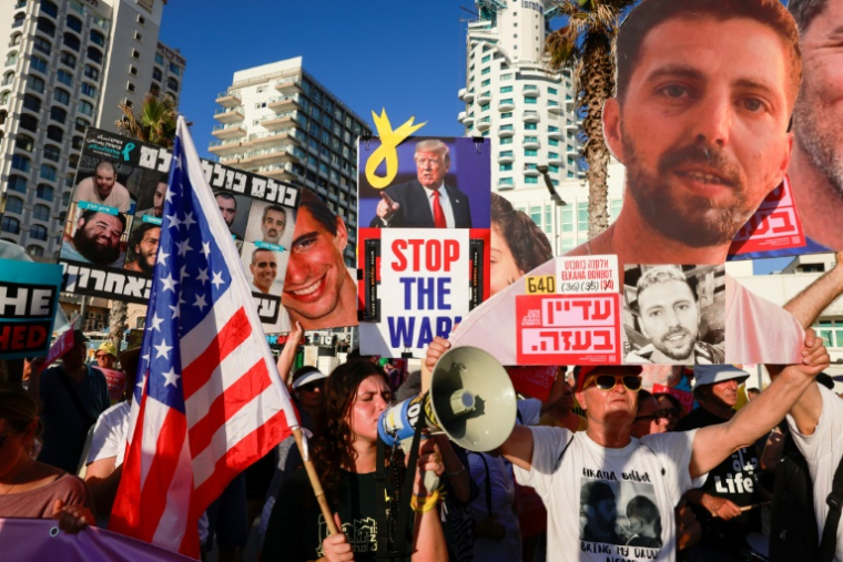 Des militants tiennent des portraits d'otages israéliens retenus à Gaza, lors d'une manifestation appelant à leur libération et à la fin de la guerre à Gaza, devant une annexe de l'ambassade des Etats-Unis à Tel Aviv, le 7 juillet 2025 ( AFP / Menahem Kahana )