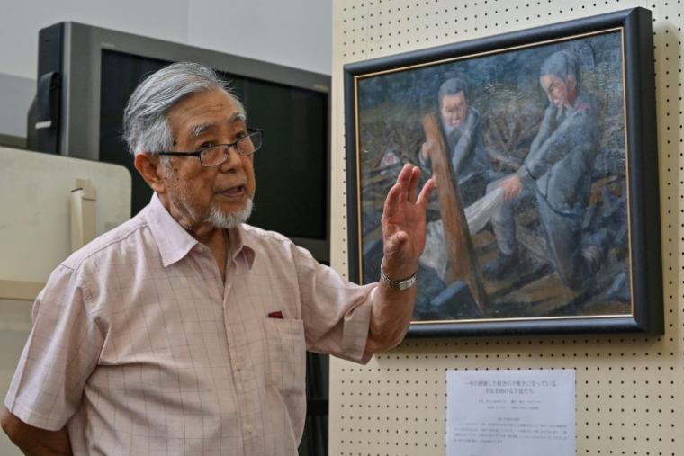 Photo prise le 27 juin 2025 à Hiroshima de Mikio Saiki, un survivant de la bombe atomique, présentant aux médias des peintures réalisées par des élèves dans le cadre d'un projet visant à préserver les témoignages des survivants ( AFP / Richard A. Brooks )