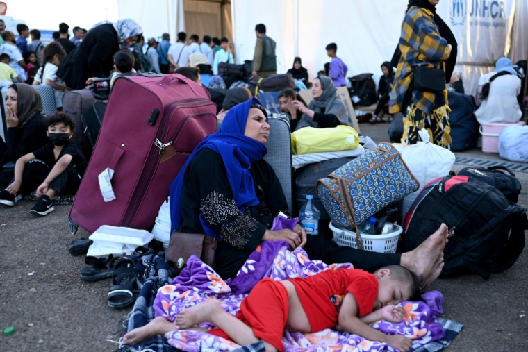 Des Afghans à leur arrivée au poste-frontière d'Islam Qala, à la suite de leur expulsion d'Iran, le 28 juin 2025 ( AFP / Wakil Kohsar )