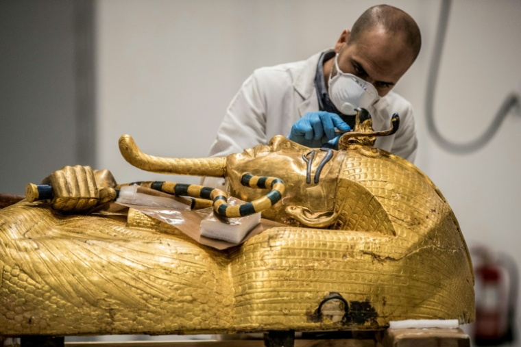 Un archéologue effectue des restaurations sur le sarcophage en or de l'ancien pharaon égyptien Toutânkhamon au laboratoire de restauration du Grand Musée égyptien (GEM) à Gizeh, dans la banlieue sud-ouest du Caire, le 13 avril 2020 en Egypte ( AFP / Khaled DESOUKI )