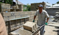 Des ouvriers construisent une maison avec des parpaings en riz, dans le village de Kyzyl-Kiya, dans le sud du Kirghizistan, le 22 mai 2025 ( AFP / Guliza Urustambek kyzy )